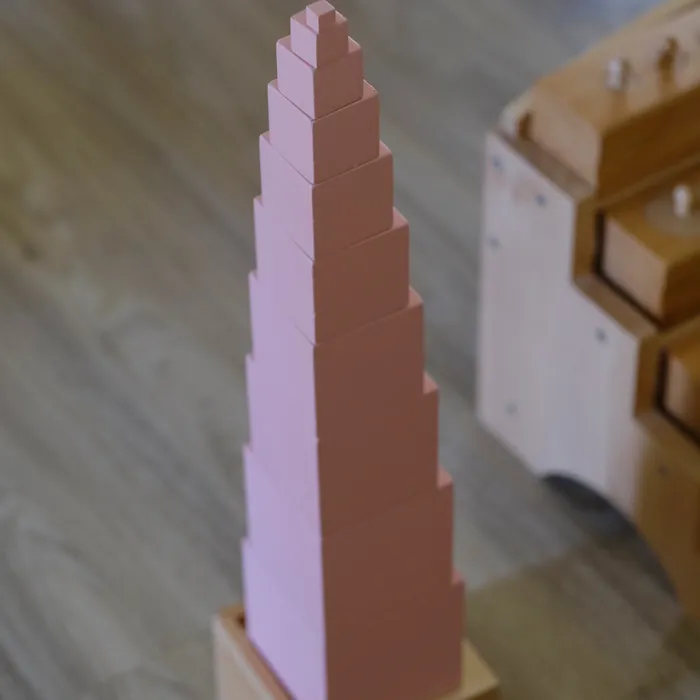 The Montessori pink tower on a wooden classroom floor