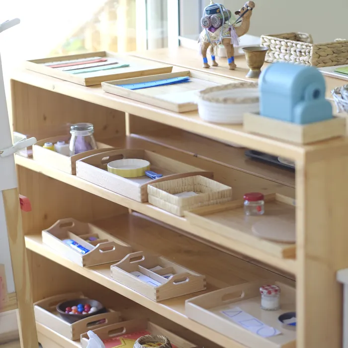 Montessori practical-life shelves with natural materials