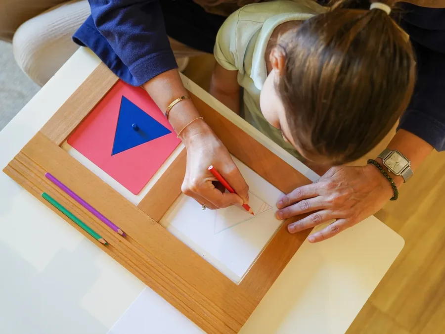 A child working with a hands-on Montessori geometry material at their own pace