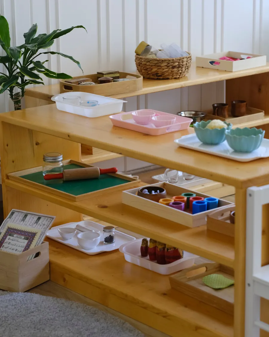 Montessori material trays on child-height shelves